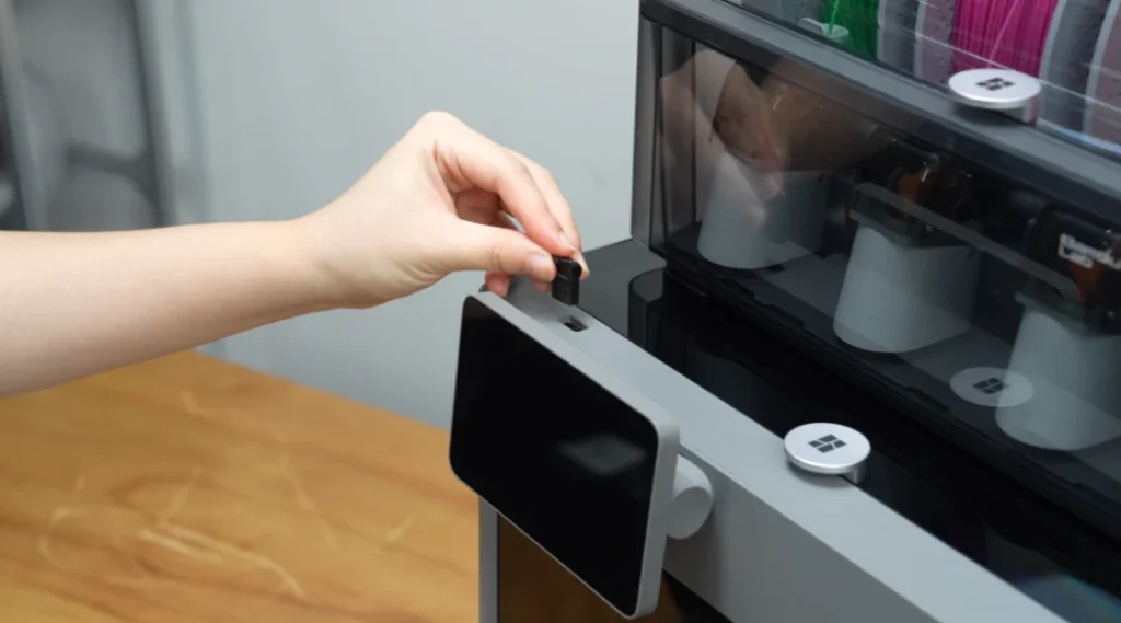 A USB drive being inserted beside the P2S touchscreen.