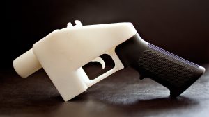 White printed pistol with a dark textured grip on a table