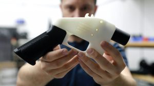 Person holding a white printed pistol with a black grip